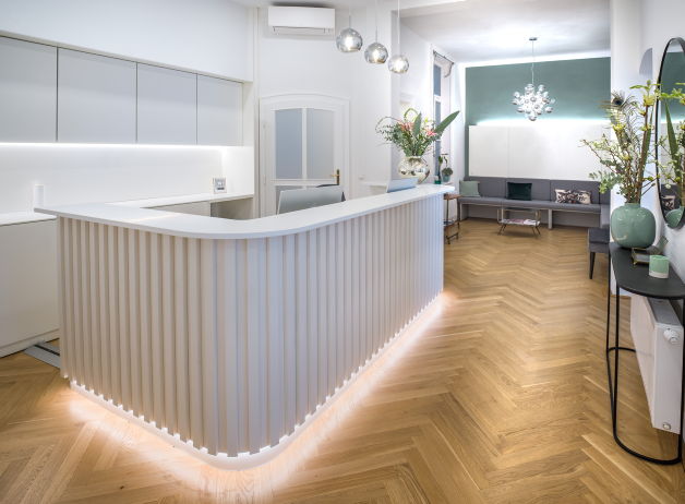 Moderne Empfangstheke mit vertikal gerillter Oberfläche, stimmungsvoller LED-Beleuchtung und dekorativer Rückwand