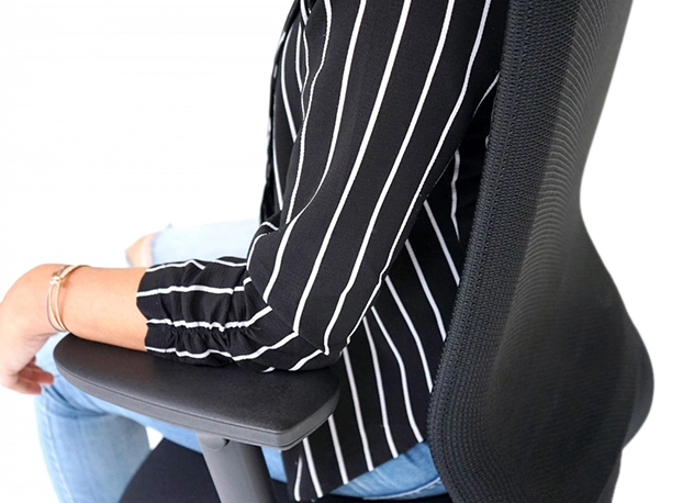 Frau sitzt entspannt auf ergonomischem Bürostuhl mit schwarzer Netzrückenlehne