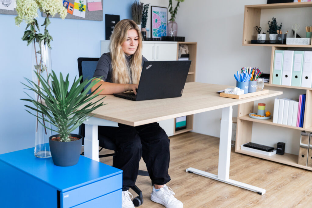 Mitarbeiterin arbeitet an modernem hali Arbeitsplatz mit ergonomischer Ausstattung