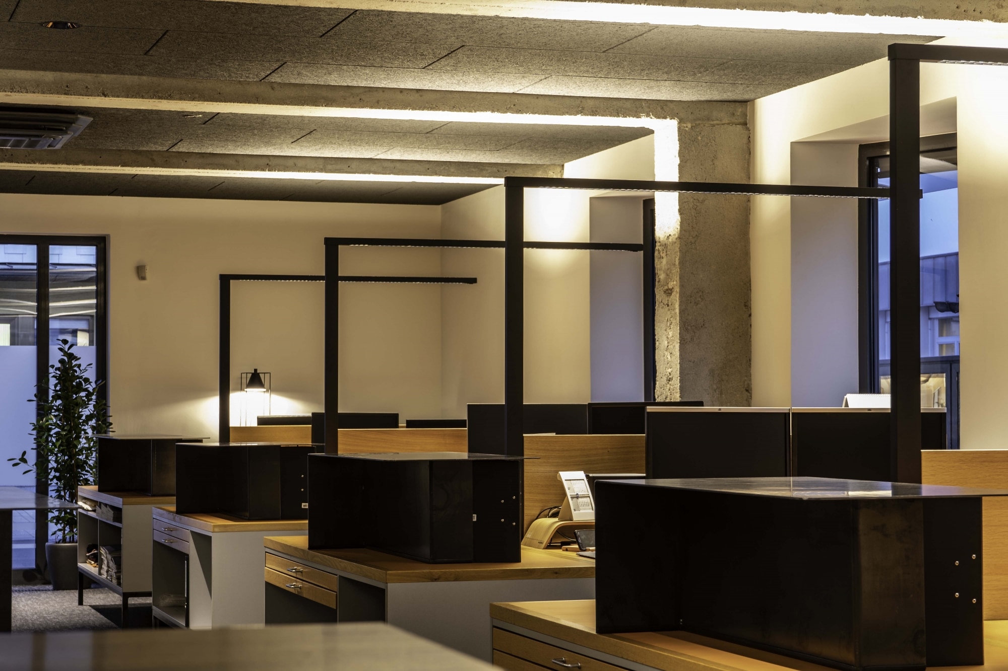 Großraumbüro mit Stehleuchten Lens von Molto Luce in schwarzer Ausführung. Die Leuchtmittel der Stehlampe Lens strahlen nach oben anstatt direkt auf den Arbeitsplatz, so entsteht eine angenehme Arbeitsatmosphäre.