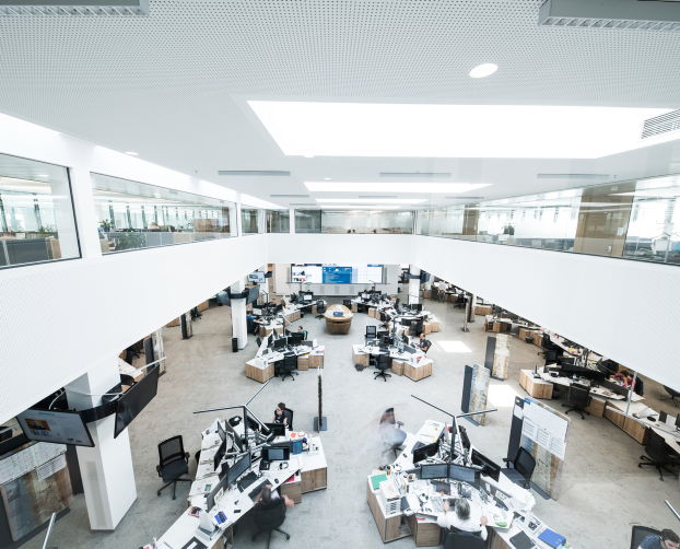 Zentrale Ansicht auf den offenen Newsroom mit zahlreichen Arbeitsplätzen und Screens