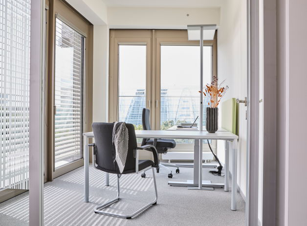 Flexibler Arbeitsplatz bei STRABAG Hamburg mit höhenverstellbarem Schreibtisch am Fenster