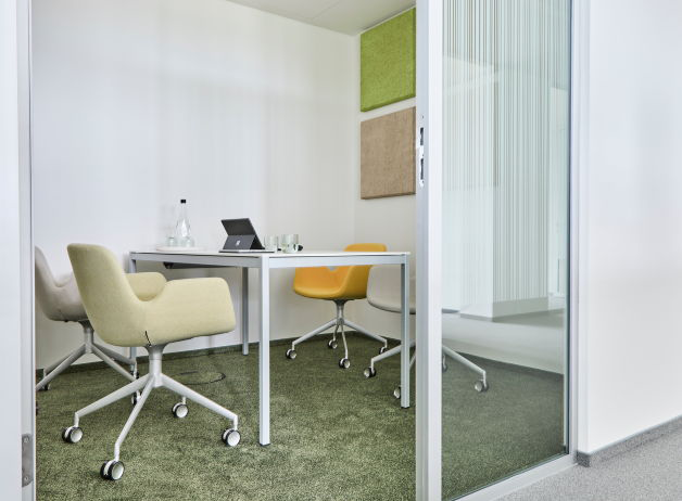 Besprechungsraum im STRABAG BORX Bürogebäude in Hamburg mit Tisch, Drehstühlen und Akustikelementen