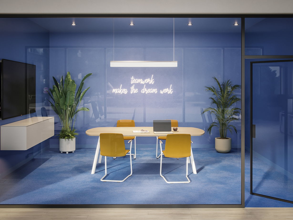 Konferenzraum mit gelben Curve Besucherstühlen und großem Tisch vor blauer Wand mit Leuchtschrift.