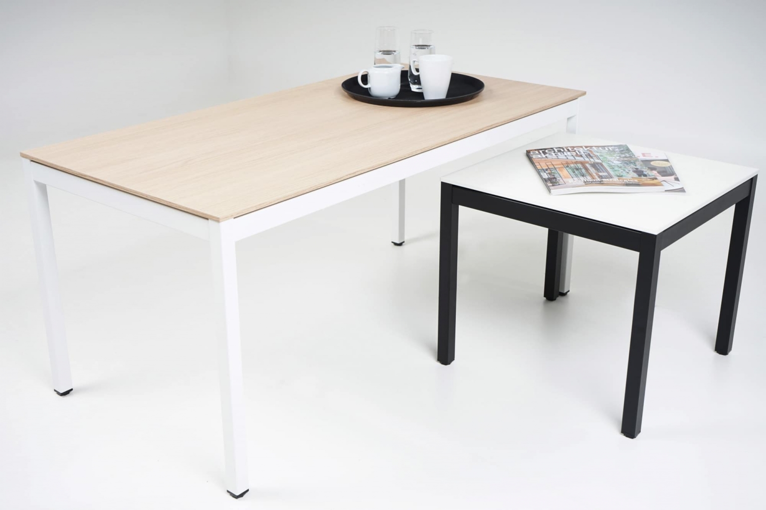 Couchtische in 2 verschiedene Höhen mit Tischgestellen in weiß und schwarz sowie Tischplatten in weiß und Holzoptik.
