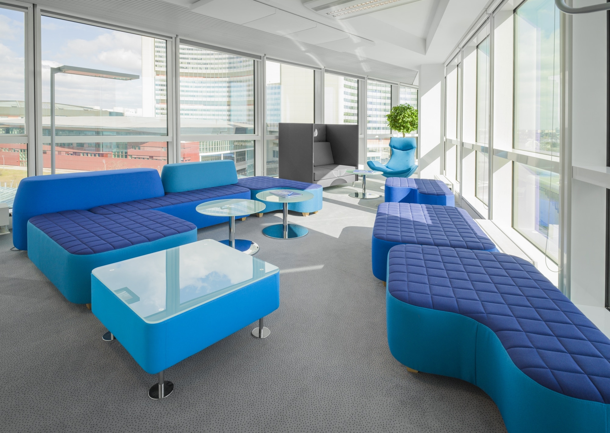 Ambientebild Loungebereich mit bequemen Loungemöbel unterschiedlicher Ausführung in blau.