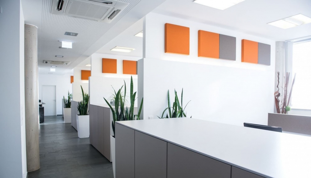 Open Office Büroszene mit Akustikwandabsorbern in orange und grau.