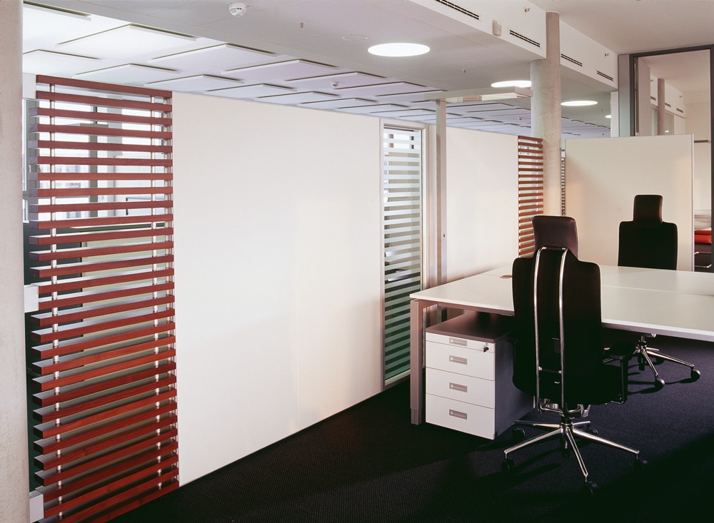 Systemstellwände Prime Line der Marke AOS Akustik zur Raum-in-Raum Bildung in weiß mit integrierten Lamellenwänden in Holzoptik.