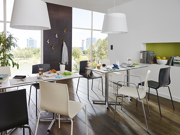 Ambientebild Mitarbeiterküche ausgestattet mit Stühlen Nameless der Marke SMV mit 4-Fuß Gestell aus Metall und Armlehnen aus Metall sowie Sitzschale aus Kunststoff in weiß beziehungsweise schwarz.