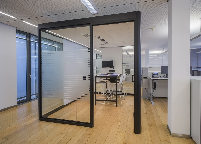 Büro und ein Raum in Raum System aus Glas mit schwarzer Umrahmung